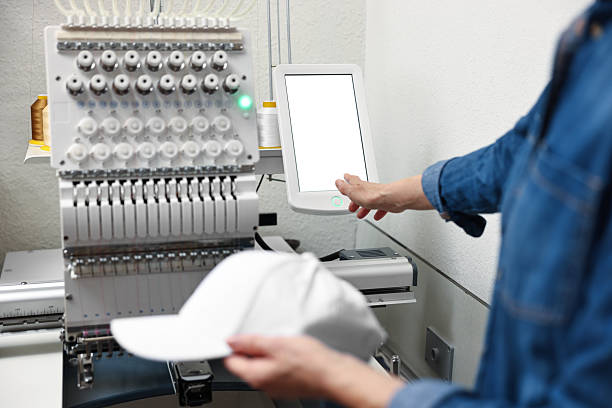 Woman with blank baseball cap for print using embroidery machine indoors, closeup