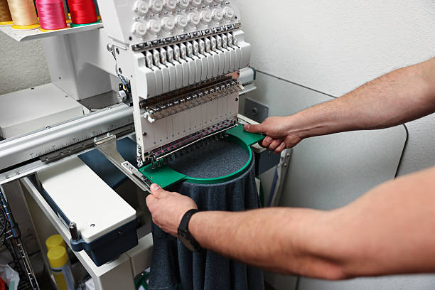 istock Man using embroidery machine to make design on T-shirt indoors, closeup 2215824150