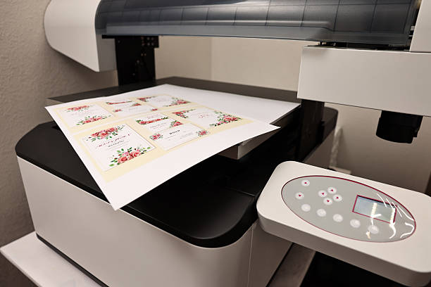 istock Modern printer with printed wedding invitation cards indoors, closeup. Printing house 2215824229