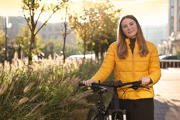 istock Woman with bicycle outdoors on sunny day 2215824324