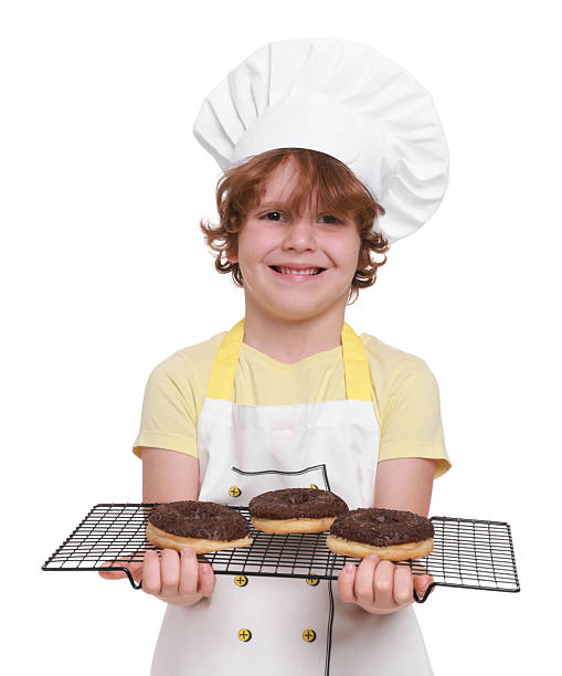 istock Little boy with donuts pretending to be pastry chef on white background. Dreaming about future profession 2215825031