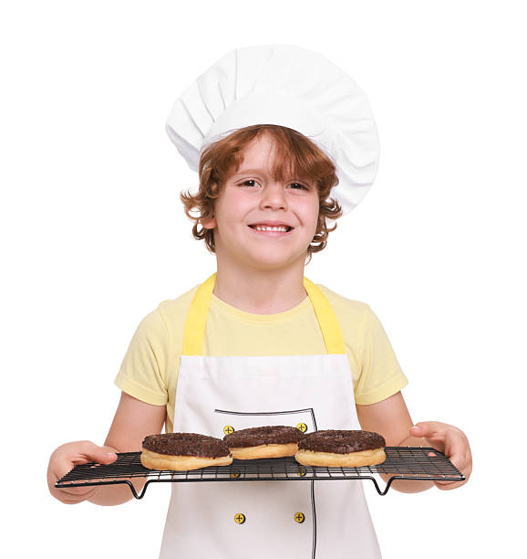 istock Little boy with donuts pretending to be pastry chef on white background. Dreaming about future profession 2215825044