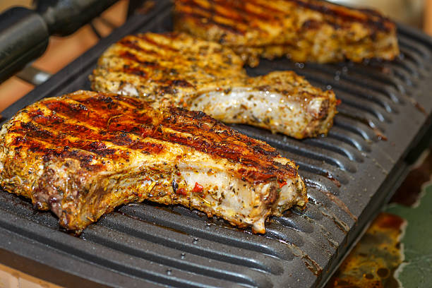 grilling steaks on a flaming grill