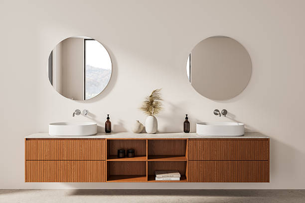 istock Modern minimalist bathroom interior with double sinks, wooden vanity, round mirrors and neutral tones, featuring elegant decor accents. 3D Rendering. 3D Rendering 2215828361