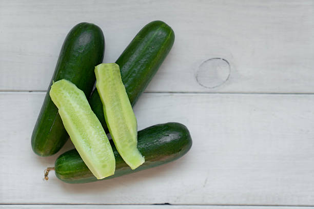istock Cucumbers and slices on wooden table 2215830025