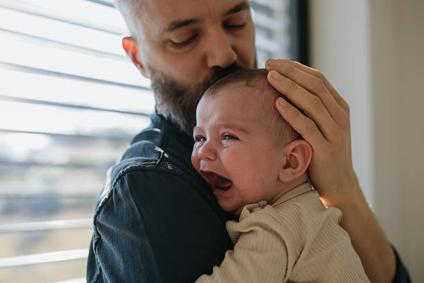 istock Father comforting his crying baby son. 2215830301