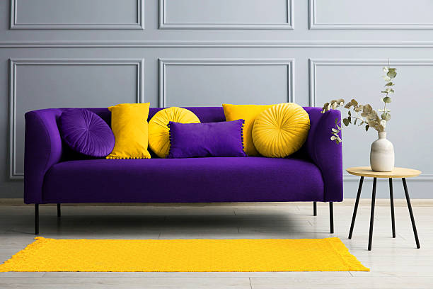 istock Stylish sofa with cushions and table near grey wall 2215831027