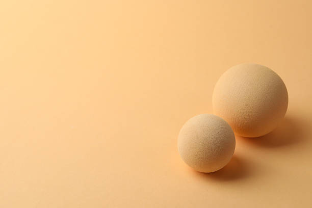 istock Two textured balls on beige background, space for text 2215831165