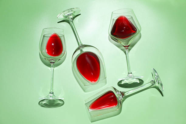 istock Glasses of red wine on light green background, flat lay 2215831174