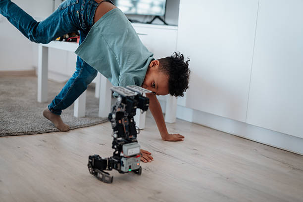 istock Boy having fun with small robot at home as part of STEM learning. 2215832582