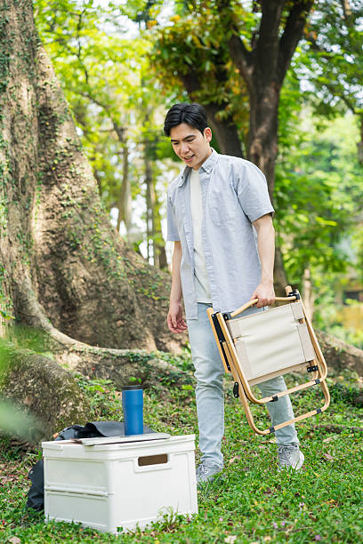 istock Man Enjoying Outdoor Activity While Setting Up a Chair in Nature 2215833174