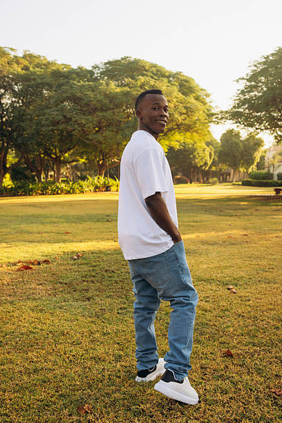 istock Smiling man walking outdoors in a sunny park during golden hour 2215834078