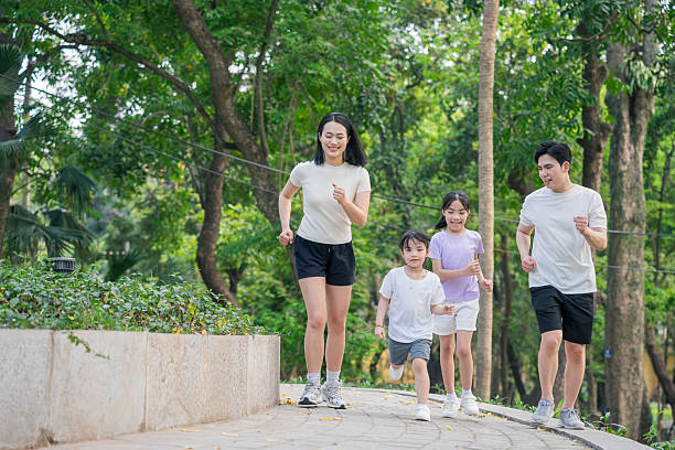 istock Family Jogging Together Outdoors in a Lush Park Setting 2215836290