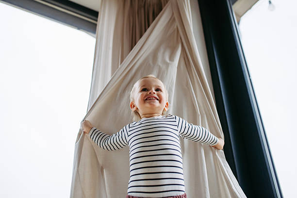 istock Adorable toddler boy playing hide and seek at home. 2215836978