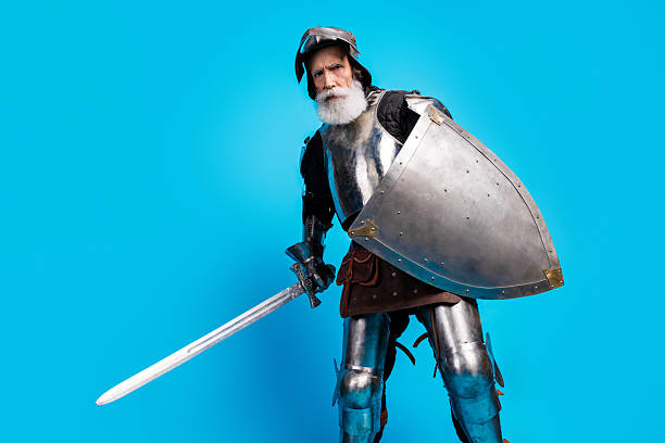 istock Mature knight in shining armor with shield and sword on a blue background portraying medieval nobility and historical chivalry 2215837655