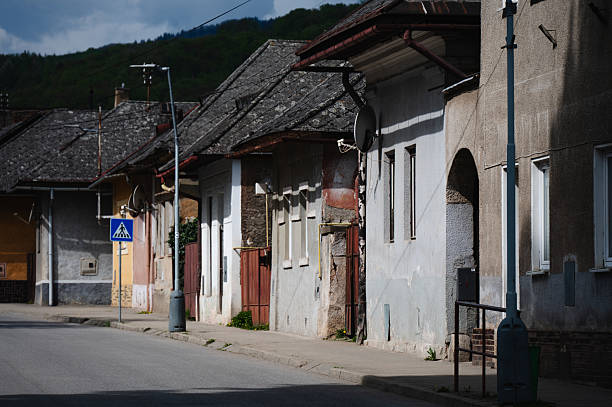 istock Old village street with worn facades and tiled rooftops 2215840339
