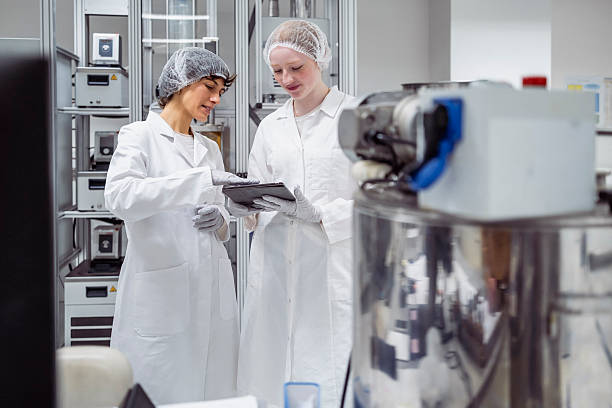 istock Female Pharmaceutical Scientists in White Lab Coats Reviewing Data in Modern Laboratory 2215841836