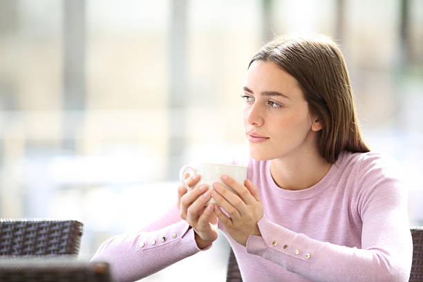 istock Pensive serious woman holding coffee cup looking at side 2215842055