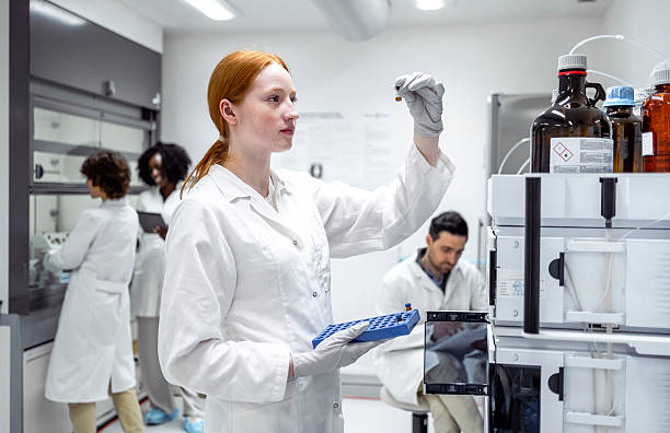 istock Young Female Scientist in a Modern Laboratory Analyzing Samples in a White Lab Coat 2215842289