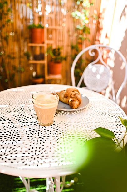 istock Cappuccino and croissant served on a white table in a peaceful garden 2215842362
