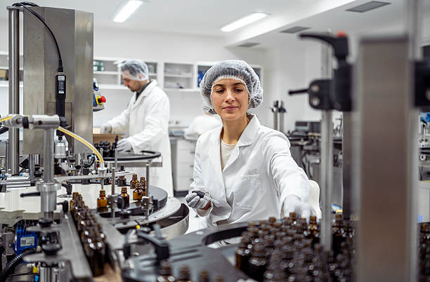 istock Mid Adult Woman Operating Pharmaceutical Production Line While Wearing Protective Laboratory Uniform 2215843100