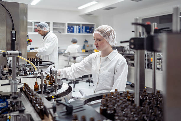 istock Young Female Lab Worker Packaging Products in Bright Clean Laboratory 2215843108