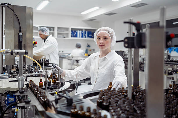 istock Young Female Lab Worker in White Coat Packaging Products in Sterile Laboratory Environment 2215843139