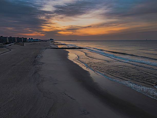 istock Serene beach sunset with gentle waves and vibrant sky. 2215843872