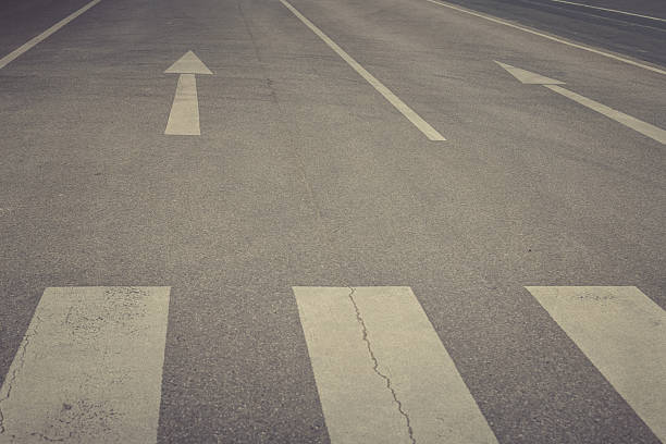 istock Guiding lines on an empty street stretch toward the horizon under a cloudy sky at dusk 2215844777