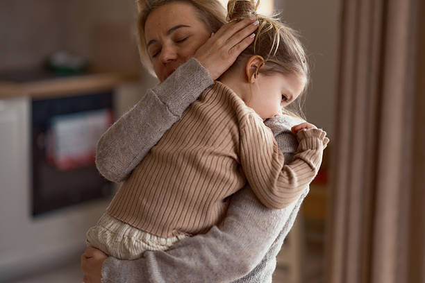 istock Crying little girl in mother's arms 2215844812
