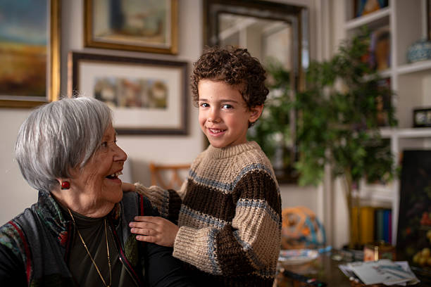 Happy loving elderly retired woman grandmother play with child kid boy grandson at home rubbing noses together expressing tenderness tender relationship enjoying affection two age generations family. High quality 4k footage