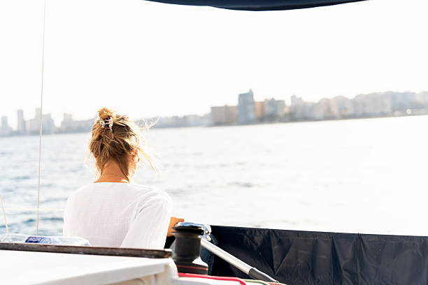 istock Woman steering sailboat on open water journey 2215846742