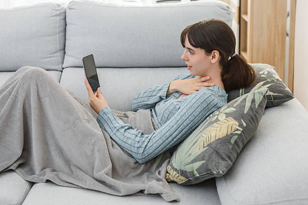 istock Young woman relaxing at home, using a tablet while wrapped in a blanket 2215848515