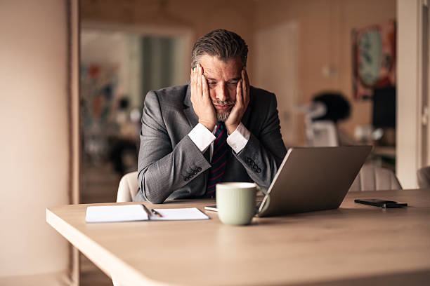 istock Concerned Businessman Working at Desk on a Laptop 2215849958
