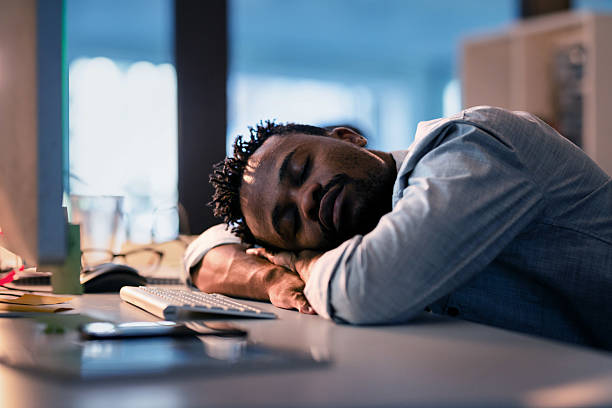 istock Tired Businessman Sleeping at Desk in Office After Working Long Hours 2215851470