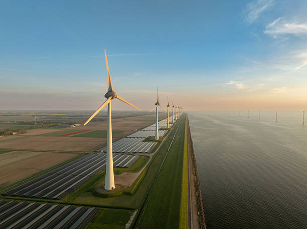 istock Wind turbines and solar panels on a lakeshore 2215851928