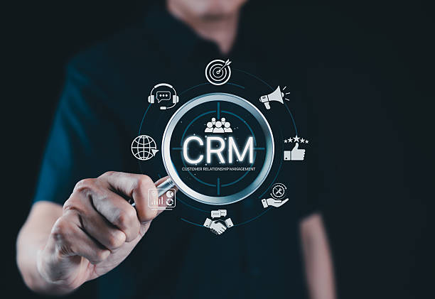 istock CRM System for Customer Relationship Management. A person interacts with CRM interface icons for support, analytics, marketing, and feedback, illustrating customer relationship management in business. 2215852432