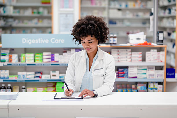 istock Professional Pharmacist Writing a Prescription in a Modern Pharmacy 2215853105