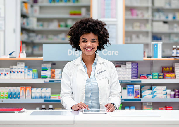 istock Smiling Pharmacist Attending Customers at a Modern Pharmacy Counter 2215853132