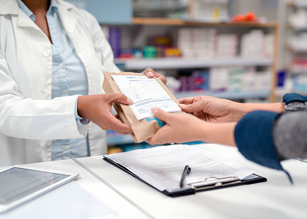 istock Pharmacist Handing Prescription Medication in a Dispensary Setting 2215853184