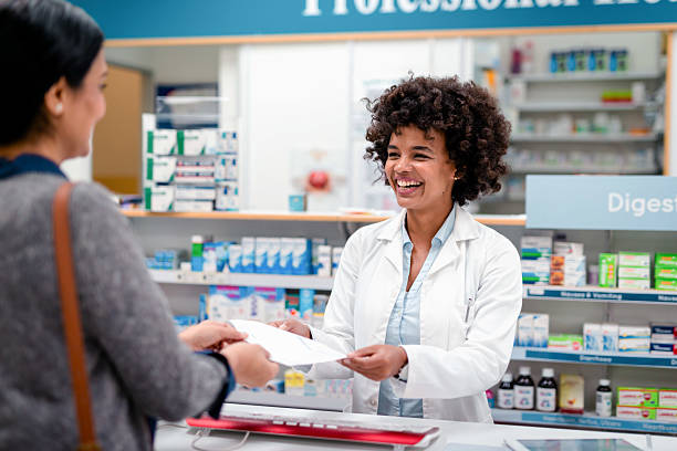 istock Friendly Pharmacist Assisting a Customer with a Prescription in a Modern Pharmacy 2215853185