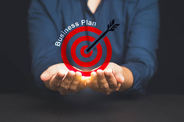 istock Businessman holding holographic target with arrow and business plan text. 2215856597