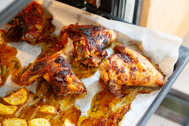chicken wings and potatoes on baking sheet, roasted together, just getting out of the oven