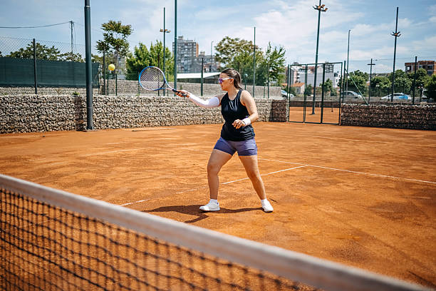 istock People playing tennis on clay court during sunny day 2215859583