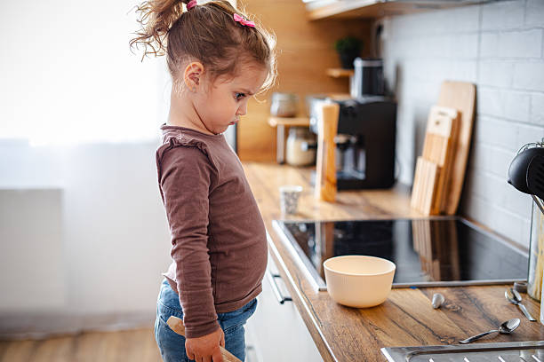 istock Cute little girl playing in kitchen 2215860164