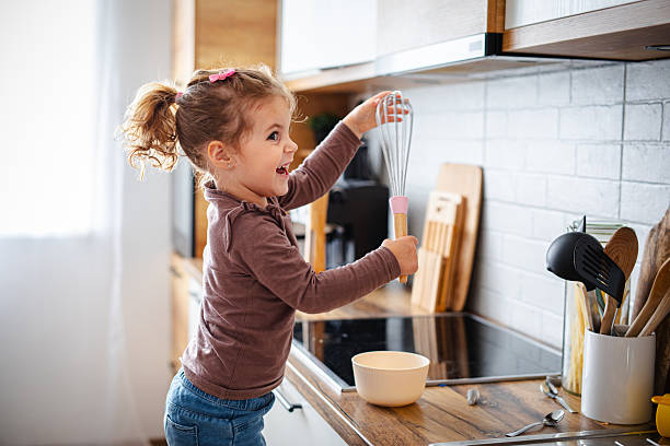 istock Cute little girl playing in kitchen 2215860194