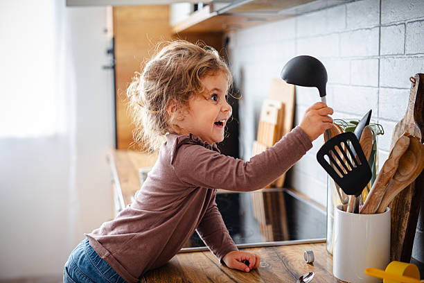 istock Cute little girl playing in kitchen 2215860226