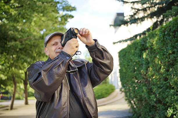 Using a Super 8 Movie Camera A man use a Super 8 film camera in the city. vintage amateur movie camera stock pictures, royalty-free photos & images