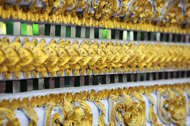 Close-up of an intricate gold leaf design contrasted with a vibrant mosaic. This decorative element showcases traditional craftsmanship in ornate architecture.