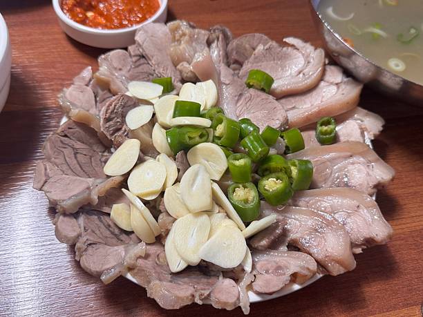 A plate of Korean boiled pork topped with diced chiles and garlic
